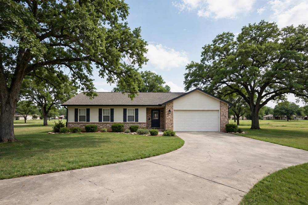 Single-story suburban ranch house with a garage, driveway and green lawn