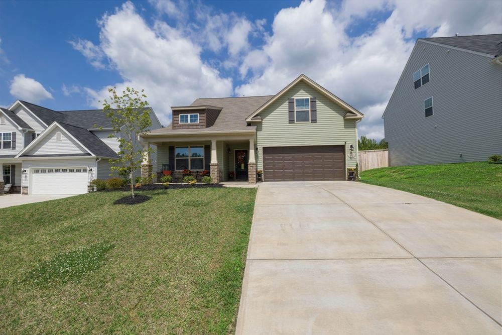 Two-story suburban house with a garage, driveway and front lawn